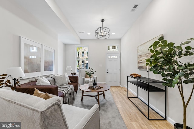 living room with a chandelier and light hardwood / wood-style floors