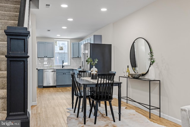 dining space featuring sink and light wood-type flooring