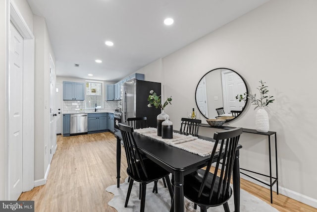 dining area with sink and light wood-type flooring