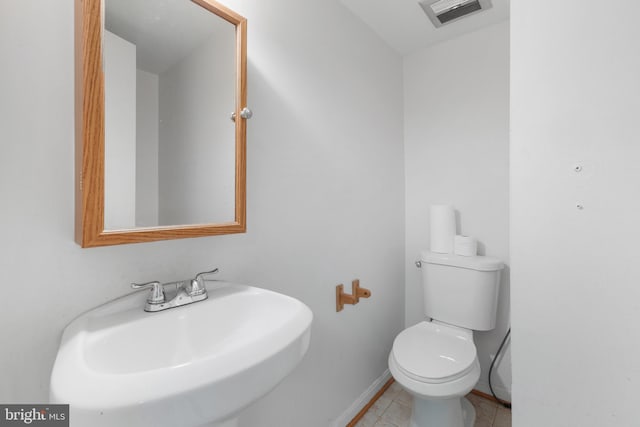 bathroom featuring toilet, tile patterned floors, and sink