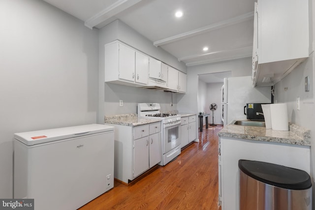 kitchen featuring sink, white appliances, white cabinetry, and light hardwood / wood-style floors