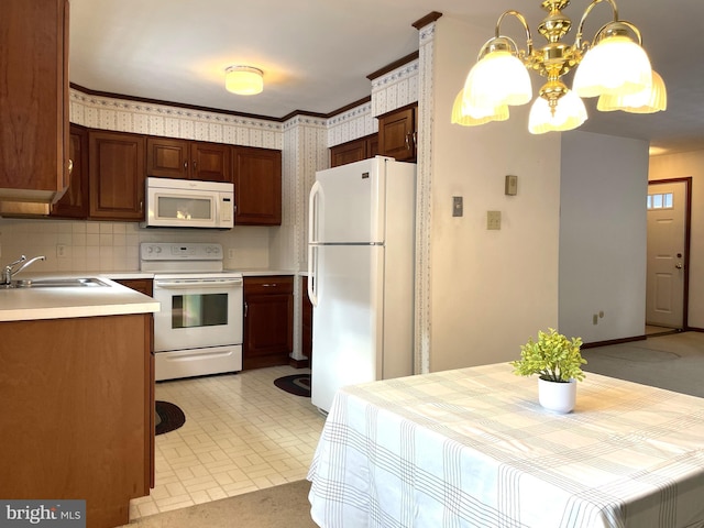 kitchen with tasteful backsplash, white appliances, a chandelier, and sink