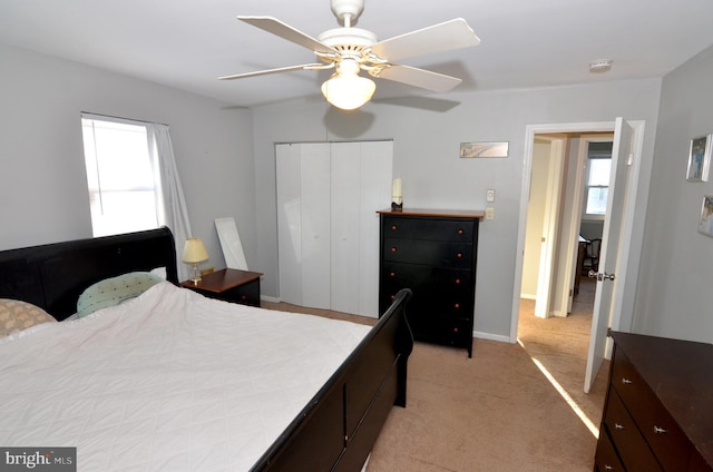 bedroom featuring ceiling fan, a closet, and light carpet