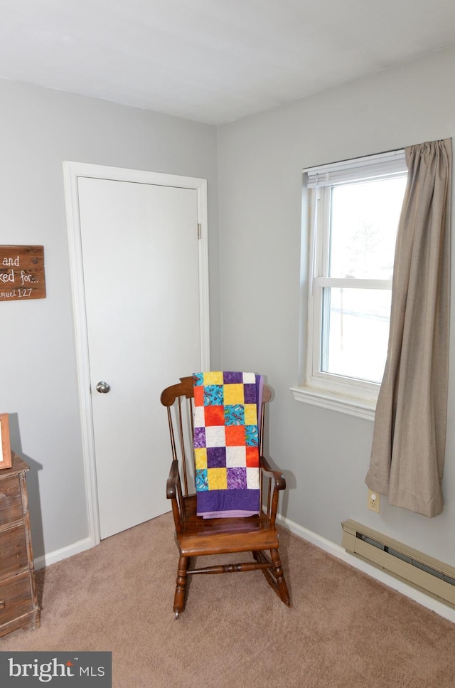 sitting room featuring carpet and a baseboard heating unit