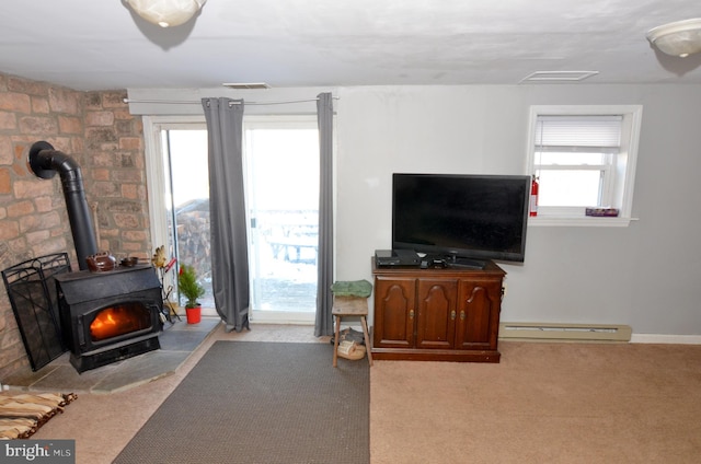 living room with a wood stove, light colored carpet, and baseboard heating