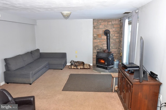 living room featuring a wood stove and light colored carpet