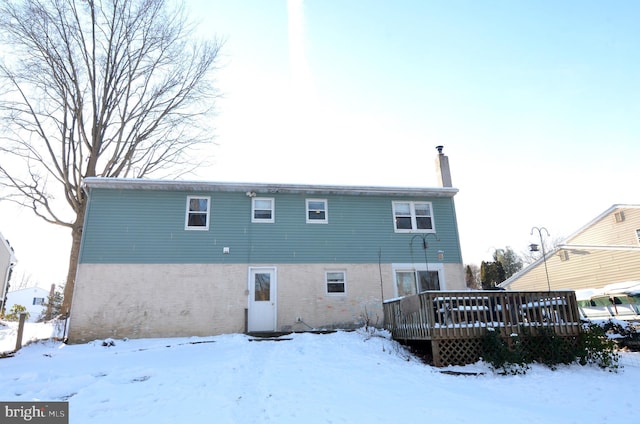 snow covered property with a wooden deck