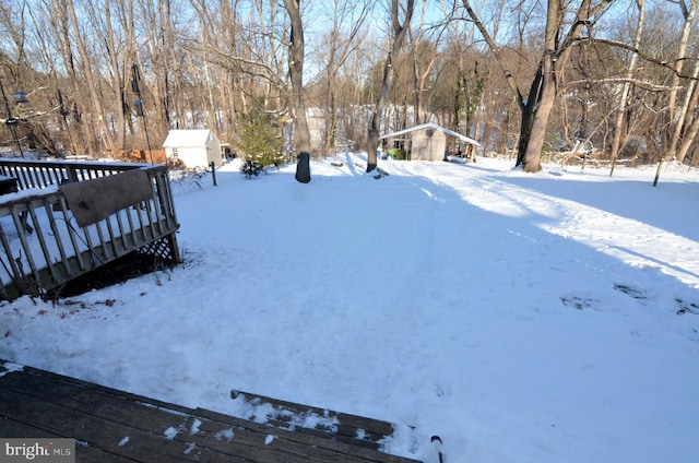 yard covered in snow featuring a wooden deck