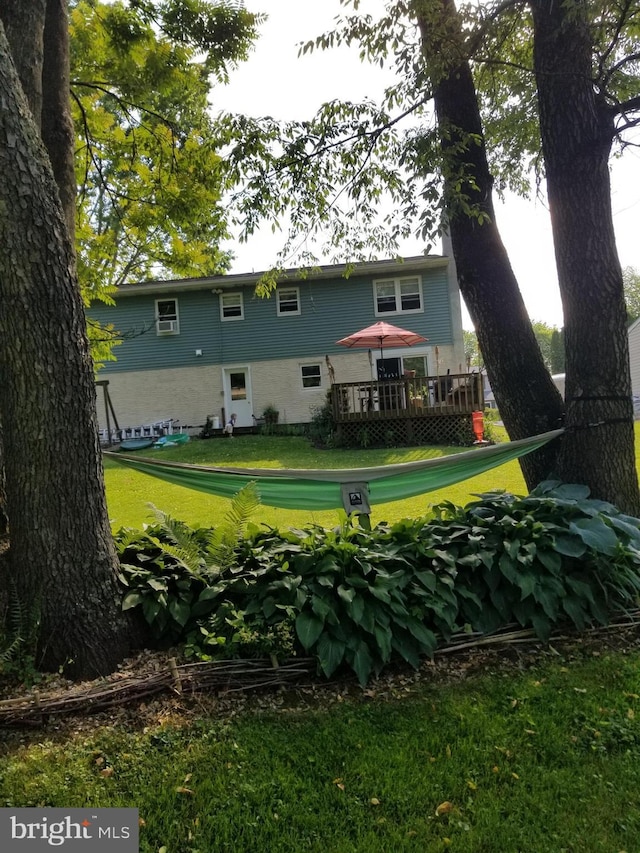 rear view of house featuring a deck and a yard