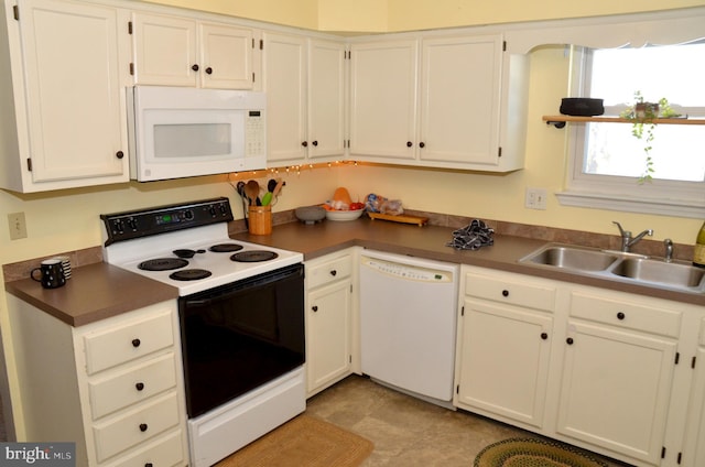 kitchen with sink, white cabinetry, and white appliances