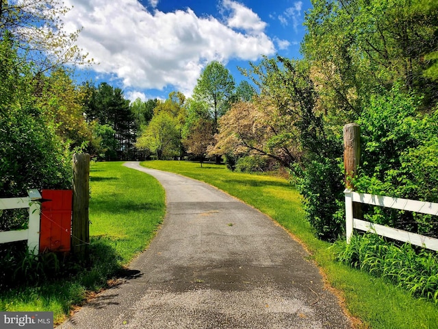 view of property's community with a yard and fence