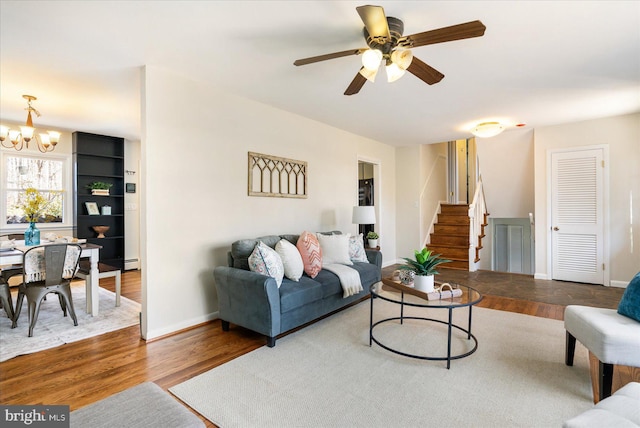 living area with stairway, wood finished floors, and baseboards