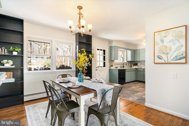 dining space featuring a baseboard radiator, a notable chandelier, baseboards, and wood finished floors