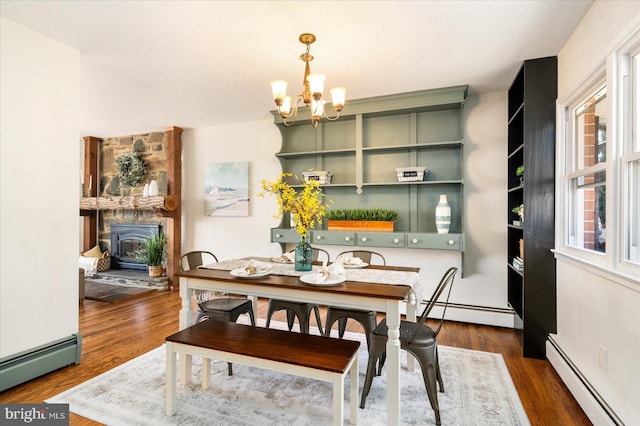 dining space featuring a baseboard radiator, dark wood-style flooring, and a notable chandelier