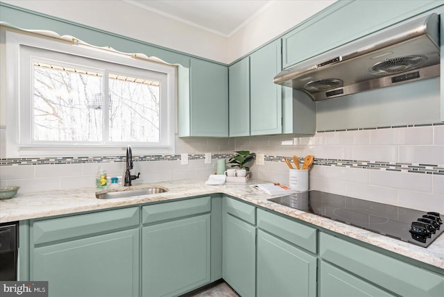 kitchen featuring tasteful backsplash, a sink, green cabinetry, under cabinet range hood, and black electric cooktop