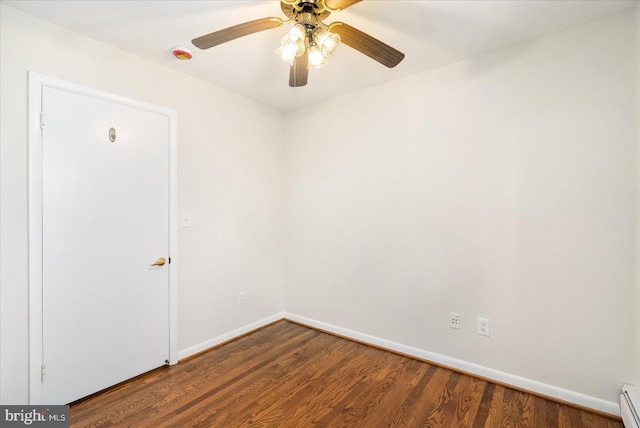 spare room with a baseboard radiator, wood finished floors, a ceiling fan, and baseboards