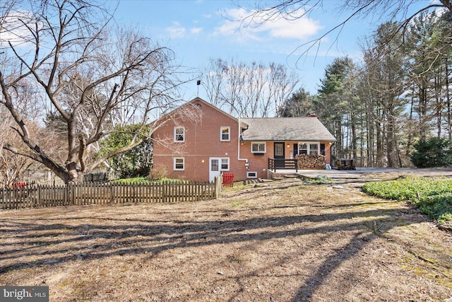 rear view of property with a fenced front yard and brick siding