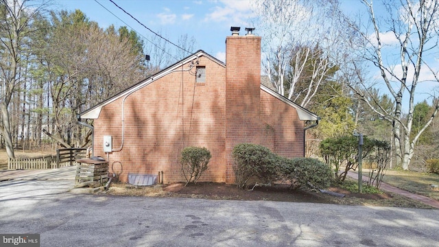 view of home's exterior with brick siding and a chimney