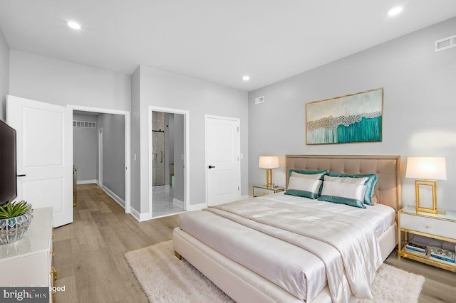 bedroom featuring light hardwood / wood-style flooring and ensuite bath