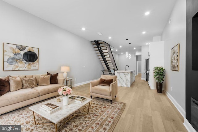 living room featuring light hardwood / wood-style floors and sink