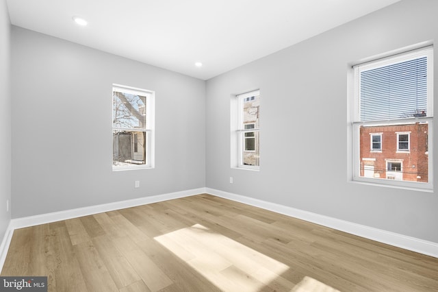 spare room featuring a healthy amount of sunlight and hardwood / wood-style floors