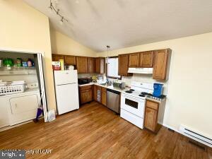 kitchen with dark hardwood / wood-style floors, decorative light fixtures, a baseboard radiator, white appliances, and lofted ceiling