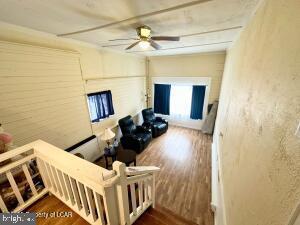 living room featuring ceiling fan and hardwood / wood-style floors