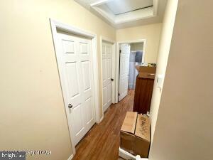 hallway with a raised ceiling and dark wood-type flooring