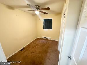 unfurnished room featuring baseboard heating and ceiling fan