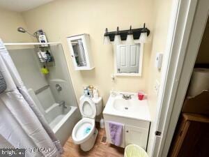 full bathroom featuring toilet, vanity, hardwood / wood-style flooring, and shower / bathtub combination with curtain