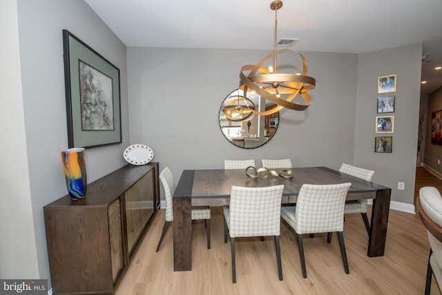 dining area with a chandelier and light hardwood / wood-style flooring