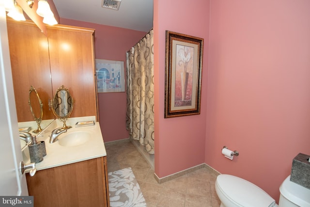 bathroom with vanity, walk in shower, tile patterned floors, and toilet