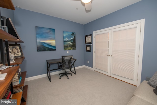 carpeted home office featuring ceiling fan