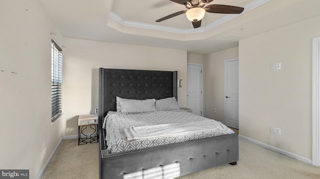 bedroom with ceiling fan, ornamental molding, light colored carpet, and a raised ceiling