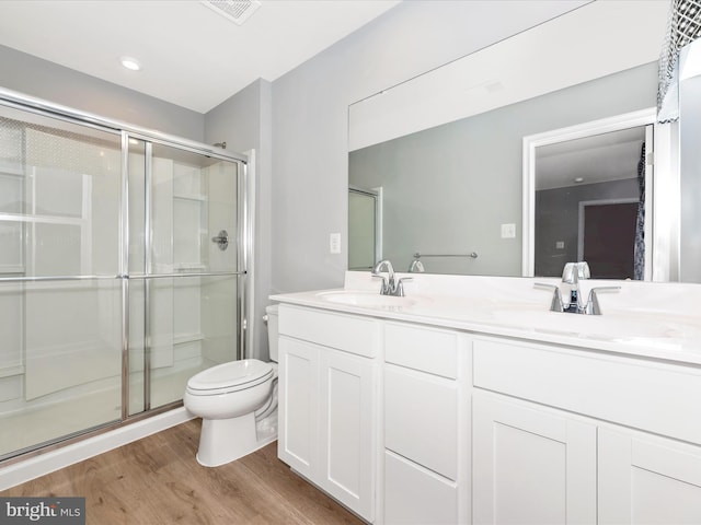 bathroom featuring an enclosed shower, vanity, toilet, and hardwood / wood-style flooring