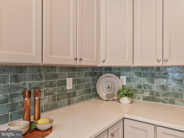 details featuring white cabinetry, light stone counters, and decorative backsplash