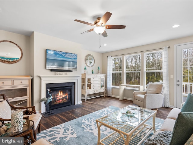 living room featuring dark wood-type flooring and ceiling fan