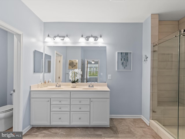 bathroom featuring vanity, toilet, and a shower with door