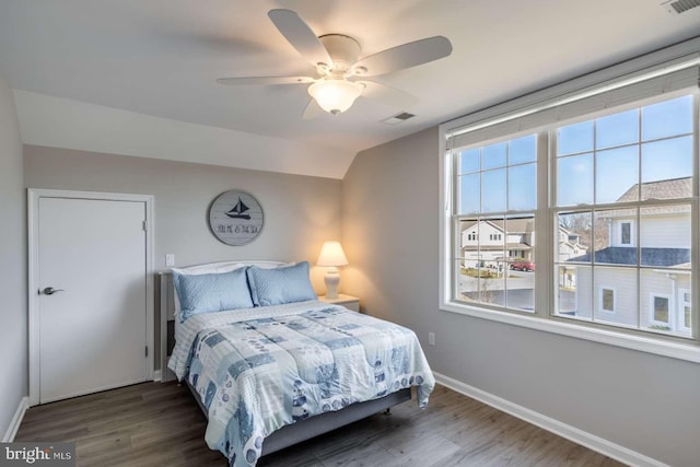 bedroom with vaulted ceiling, ceiling fan, and dark wood-type flooring