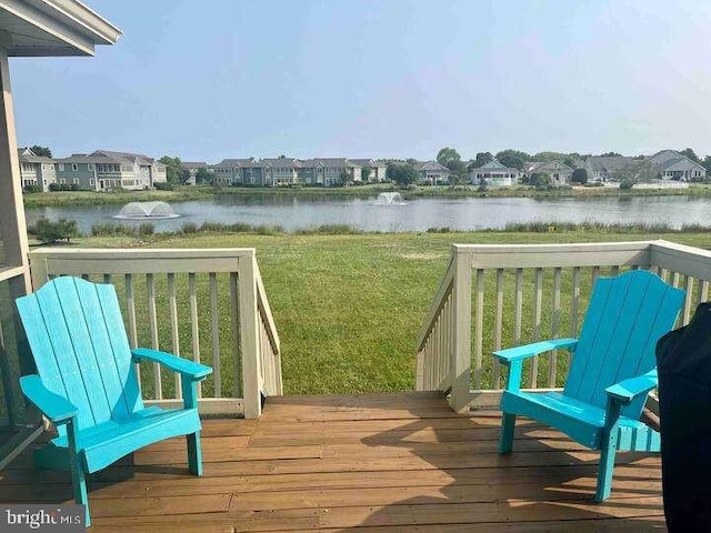 deck with a water view and a lawn