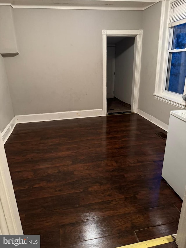 unfurnished room with washer / clothes dryer and dark hardwood / wood-style floors