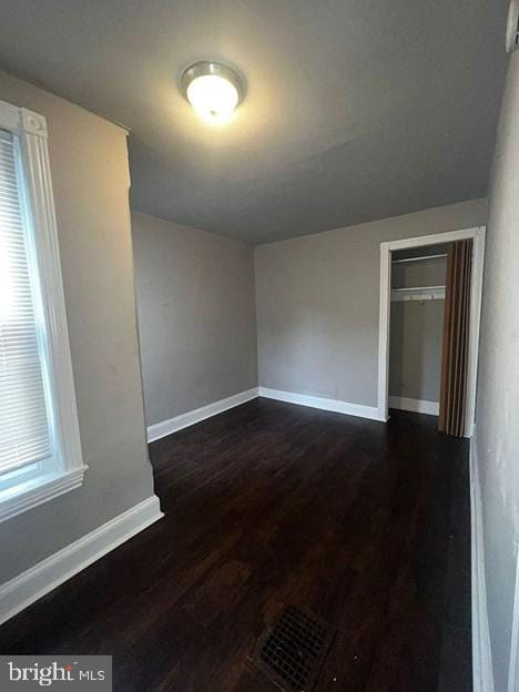 unfurnished room with dark hardwood / wood-style flooring