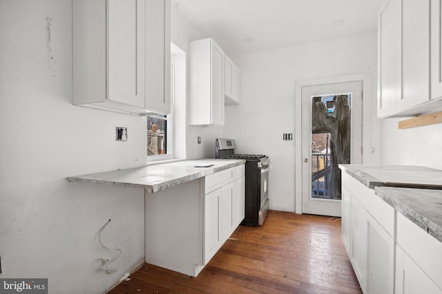 kitchen with plenty of natural light, dark wood-type flooring, white cabinets, and stainless steel gas stove