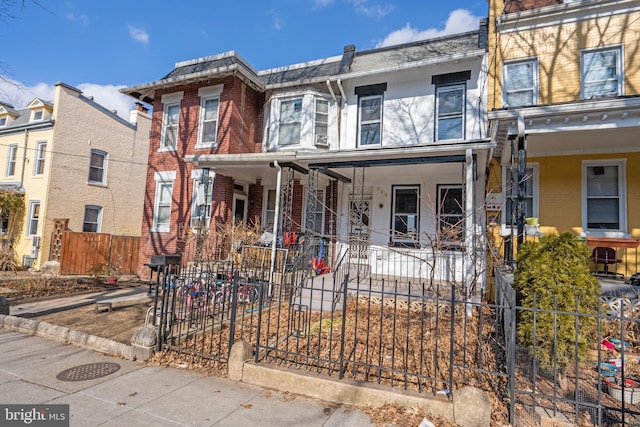 townhome / multi-family property featuring covered porch