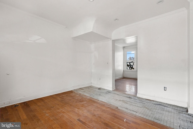 spare room featuring crown molding and wood-type flooring