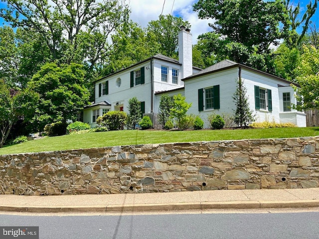 view of front of property featuring a chimney and a front yard