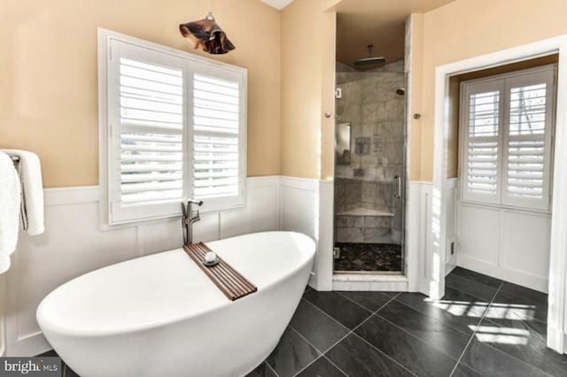 full bath with a wainscoted wall, a soaking tub, a shower stall, and tile patterned flooring