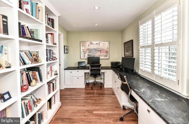 office with built in desk and wood finished floors