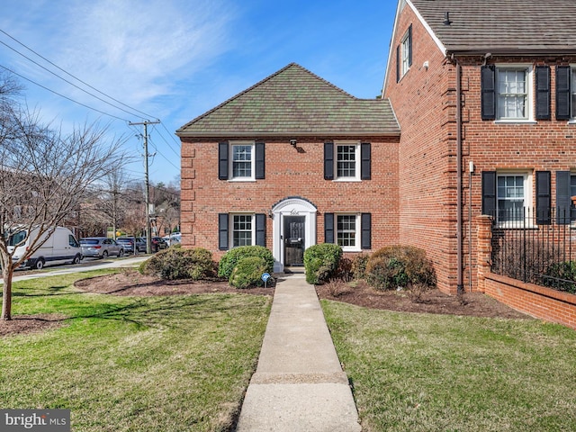 view of front of house with brick siding and a front yard