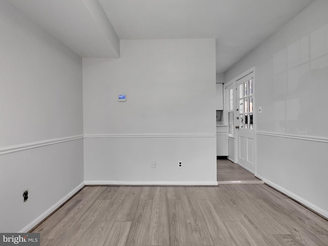 unfurnished room featuring baseboards and wood finished floors